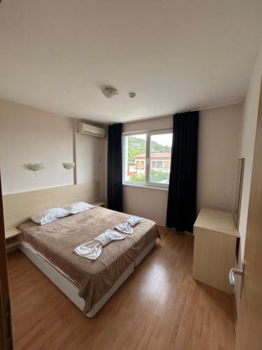 a bedroom with a bed and a window at Harmony Hills Tomovi Apartment F45 in Rogachevo