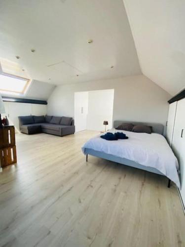 Un dormitorio grande con una cama y un sofá. en MaïTyNa - Tomorrowland Stay, en Rumst