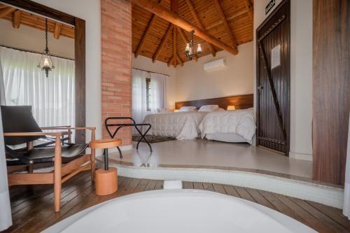 a bedroom with a bed and a desk and a table at Virá Charme Resort in Fernandes Pinheiro