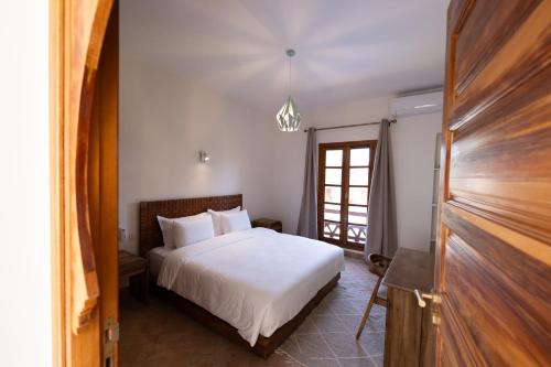 a bedroom with a white bed and a window at Villa Dar Ambre in Marrakech