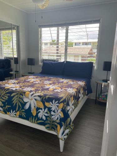 a bedroom with a bed with a floral bedspread at Beautiful Ocean View Downtown Getaway in Kailua-Kona