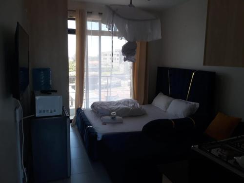 ein Bett in einem Zimmer mit Fenster in der Unterkunft Studio o76,89,76, 73, two in Kisumu