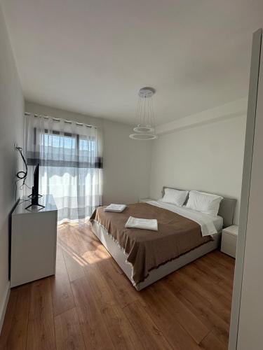 a white bedroom with a large bed and a window at Aurela Apartment 1 in Lezhë