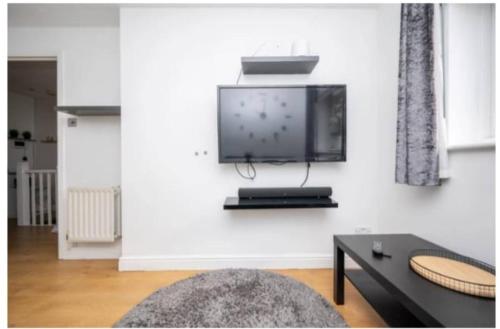 a living room with a flat screen tv on a wall at Cosy ,Private Accommodation in Lower Sydenham Station