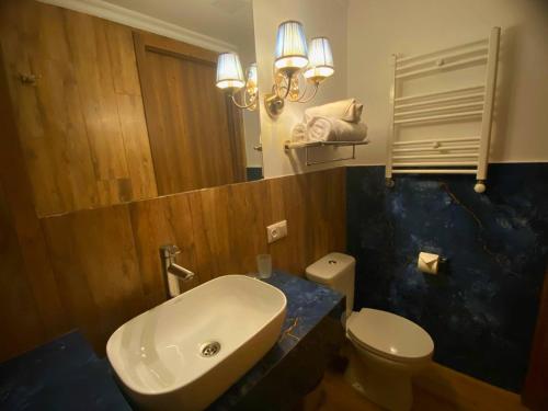 a bathroom with a sink and a toilet and a mirror at Hotel Orange Kutaisi in Kutaisi