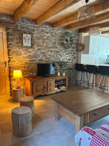 - un salon avec une télévision et une table en bois dans l'établissement Chalet pour 6 personnes du samedi au samedi, à Saint-Michel-de-Maurienne