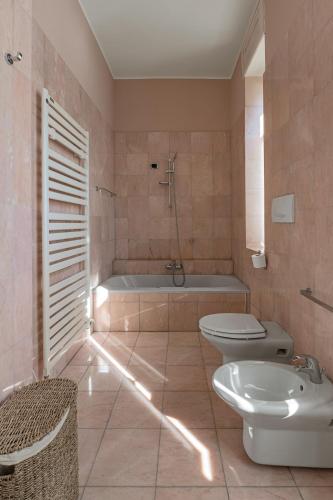 a bathroom with a tub and a toilet and a sink at Ruby Como Villa with Lake View By Petra Luxury in Laglio
