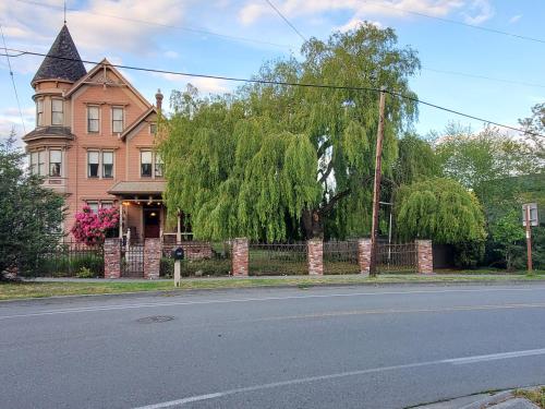 an old house with a fence in front of a street at Adams Pragge House - Victorian Bed & Breakfast in Port Townsend