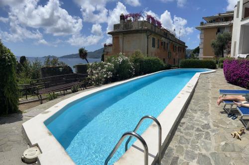 a swimming pool in front of a building at WELCOME RIVIERA Nautilus 11- vista mare-posto macchina individuale-ONLY ONE CAR-piscina condominiale-attrezzatissimo in Rapallo