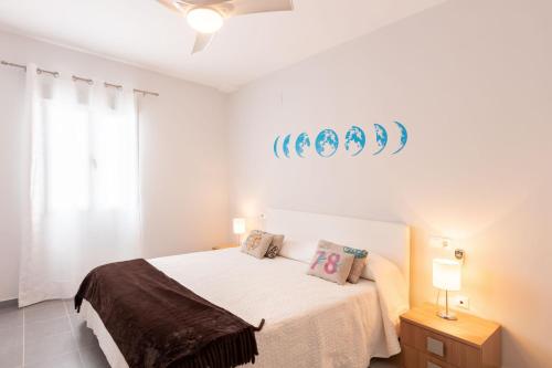 a bedroom with a bed and a sign on the wall at YOKOI Ayamonte in Ayamonte