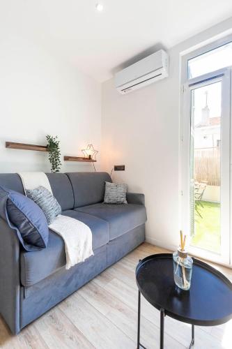 un salon avec un canapé bleu et une table dans l'établissement Villa Maska - Studios avec Terrasse proche plage et aéroport de Nice, à Nice