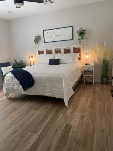 a bedroom with a large bed and wooden floors at TAYLOR PLACE-5 Minutes to Silos & Baylor in Waco