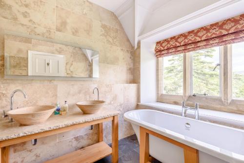 a bathroom with two sinks and a tub at Plas Gwynfryn in Llanbedr