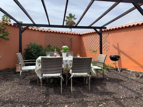 a table and chairs sitting under a pergola at Villa Chloé in San Miguel de Abona