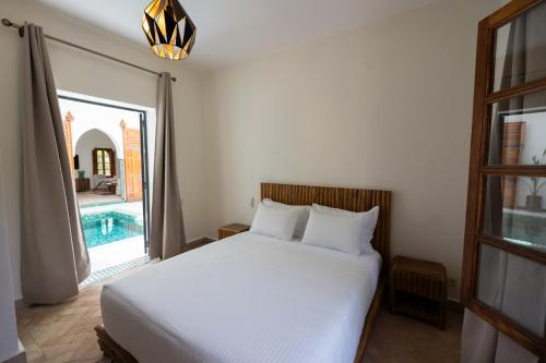 a bedroom with a bed and a swimming pool at Villa Dar Ambre in Marrakech