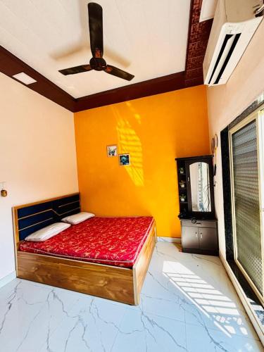 a bed in a room with a ceiling fan at Saz ins banglow in Neral