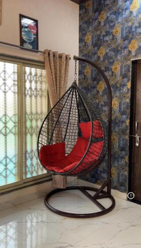 a hammock chair in a room with a wall at Saz ins banglow in Neral