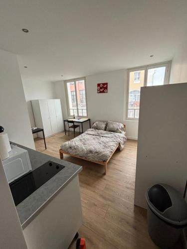 - un salon avec un lit et une table dans l'établissement Cosy neuf avec vue sur la place, à Cambrai