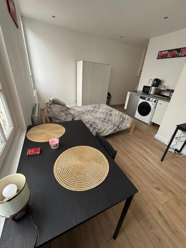 un salon avec une table et une cuisine dans l'établissement Cosy neuf avec vue sur la place, à Cambrai