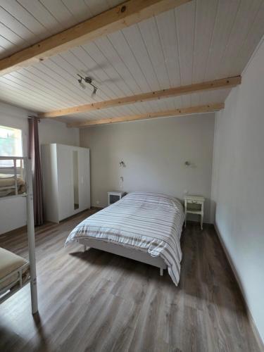 a bedroom with a bed and a wooden floor at Superbe maison de vacance in Piolenc