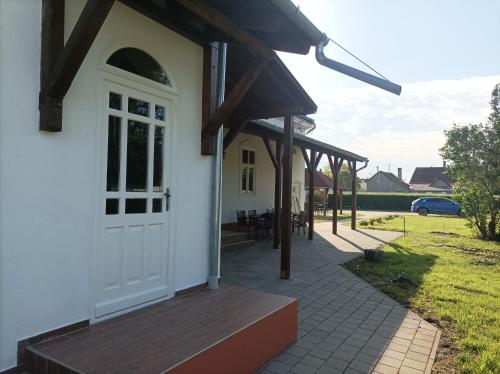 a house with a white door and a patio at Thermália Vendégházak - Tulipán Apartman in Kaba