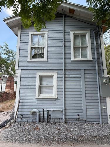 a house with two windows and a bench in front of it at Cute and Cozy Apt Near Historic Downtown Sanford in Sanford