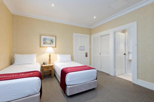a hotel room with two beds and a table at Hotel Delta Near Delhi AIRPORT in New Delhi