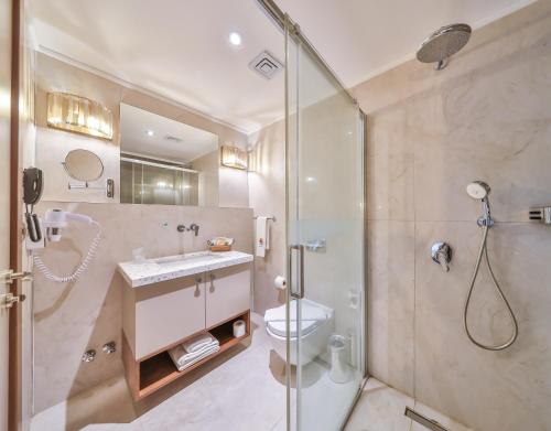 a bathroom with a shower and a toilet and a sink at Molino Hotel in Kas