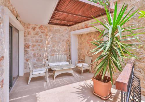 a patio with a table and chairs and a plant at Molino Hotel in Kas
