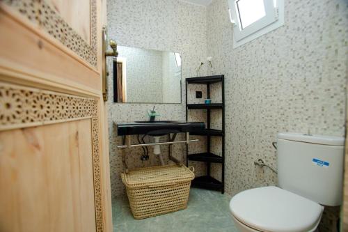 a bathroom with a toilet and a sink and a mirror at Villa Chez Lija Agafay in Aït Ali