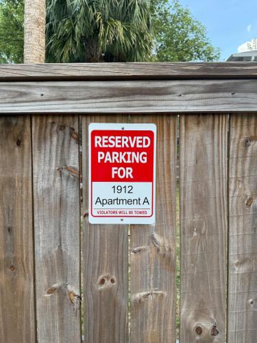 a red and white sign on a wooden fence at Cute and Cozy Apt Near Historic Downtown Sanford in Sanford