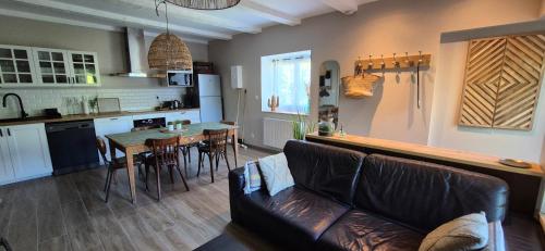 un salon et une cuisine avec un canapé et une table dans l'établissement Côté montagnes, à Doussard