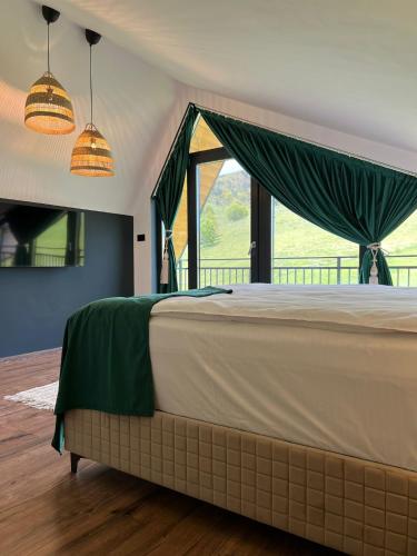 a bedroom with a bed and a large window at Mon Amor Chalet in Şirnea