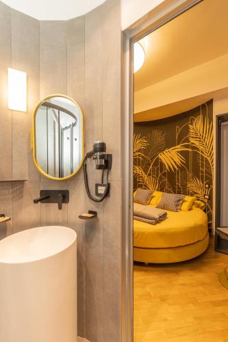 a bathroom with a yellow bed and a mirror at IL Grattacielo Di Genova in Genoa