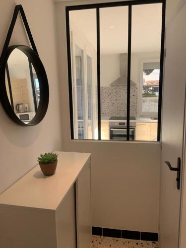 La salle de bains est pourvue d'un miroir et d'un comptoir avec lavabo. dans l'établissement Grande Villa divisée en deux logements, au Grau-dʼAgde