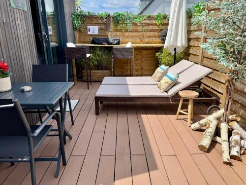 a patio with a bed and a table and chairs at Gîte Studio Alsa 15 avec Jacuzzi privatif in Fortschwihr