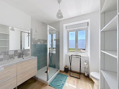 a white bathroom with a shower and a sink at Gîtes Ti Tud-Kozh Le Guébriand et L'Arguenon in Pluduno