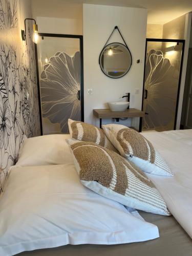 a bedroom with a bed with pillows and a mirror at Villa Simone in Arthémonay