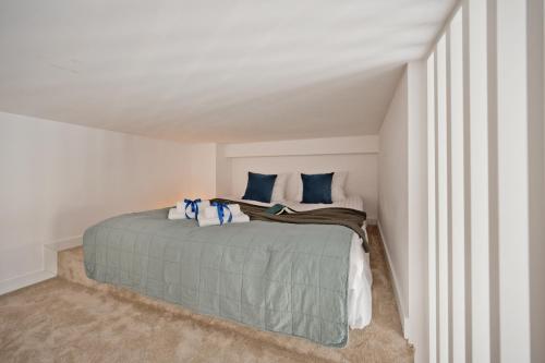 a bedroom with a bed with blue pillows at Aparthotel Anchoria BlueApart in Mechelinki