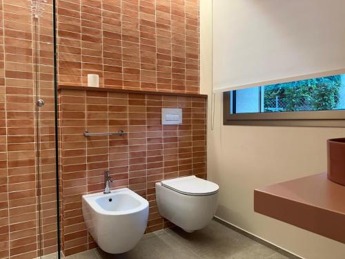 a bathroom with a toilet and a glass shower at Appartamento Toscanini in Milano Marittima