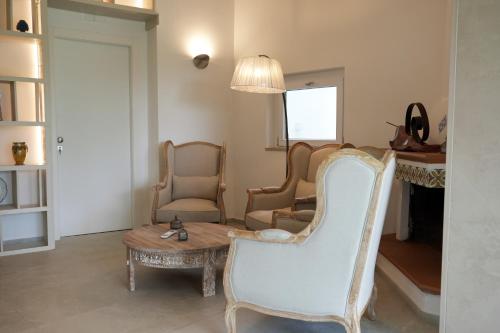 a living room with a table and chairs at Praialonga Suites with Pool and Garden in Le Castella