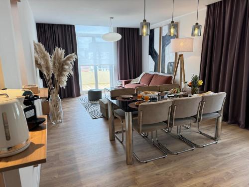 a living room with a table and chairs and a couch at Hélios Plage in Berck-sur-Mer