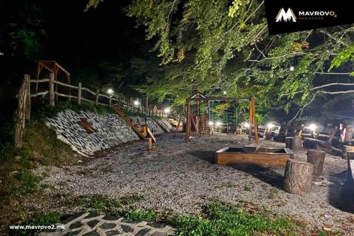 a park at night with a playground with a swing at Mavrov02 Residence in Mavrovo