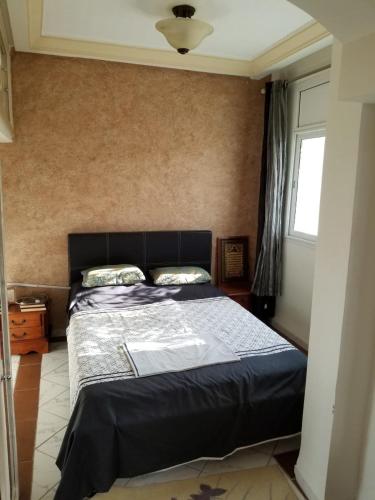 a bedroom with a bed with a black headboard at Studio with Panoramic View in Kairouan