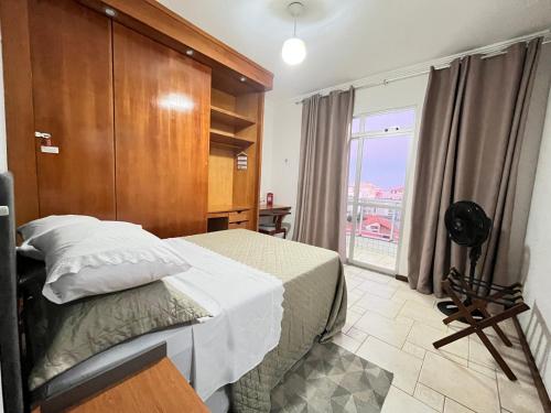 a bedroom with a bed and a large window at Cobertura 403 Braga · Complete apartment with private pool Cabo Frio in Cabo Frio