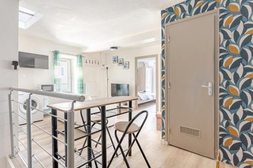 une cuisine et un salon avec une table et des chaises dans l'établissement Appartement 2 chambres Cosy proche Centre Ville, à Clermont-Ferrand