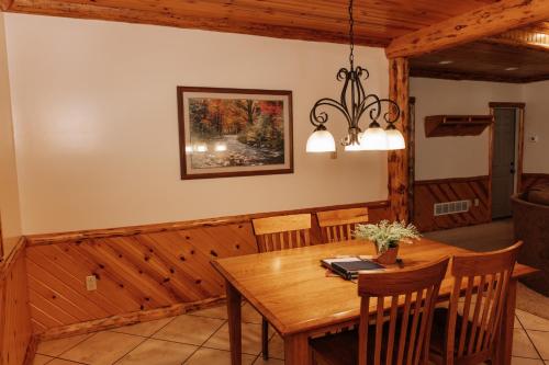a dining room with a wooden table and chairs at Sojourner's Lodge & Log Cabin Suites in Dundee