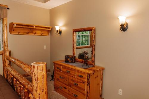 a bedroom with a dresser and a mirror at Sojourner's Lodge & Log Cabin Suites in Dundee