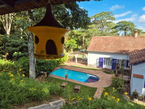 a bird house hanging over a swimming pool at Loft Cerejeira no Sítio Gaia Miguel Pereira RJ in Miguel Pereira