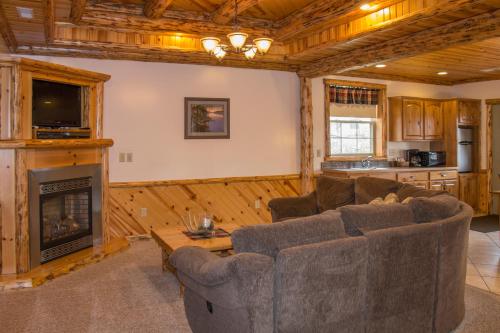 a living room with two couches and a fireplace at Sojourner's Lodge & Log Cabin Suites in Dundee